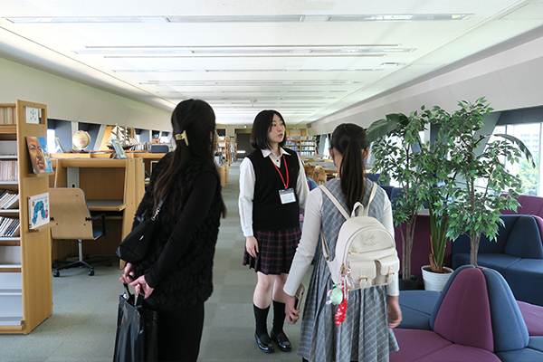 中村AMBASSADORによる校内見学。窓から清澄公園が一望できる図書室を案内する様子