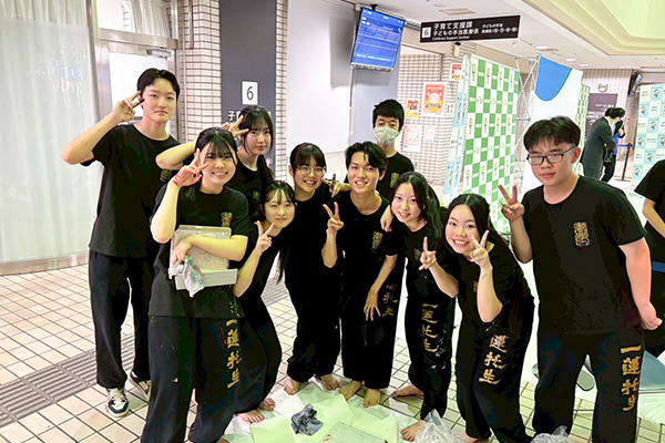 書道パフォーマンスで使用する黒い衣装での集合写真