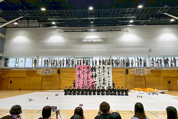 文化祭での書道パフォーマンスの様子。多くの観覧者が見守る中堂々とした作品を披露