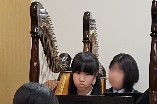 楽譜を見ながら熱心にハープを演奏するK.I.さん