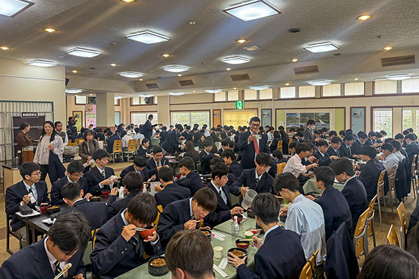 宿泊学習での食事の様子。大きな部屋が生徒で埋め尽くされている