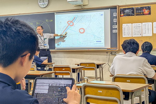 教室でパソコンを操作しながら、写真データに含まれる位置情報や地図情報を解析している様子