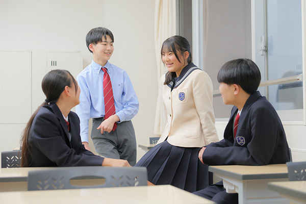 教室で談笑する男子生徒2名と女子生徒2名の4人