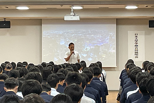 校長先生が前方に立って、生徒たちにメッセージを伝えている