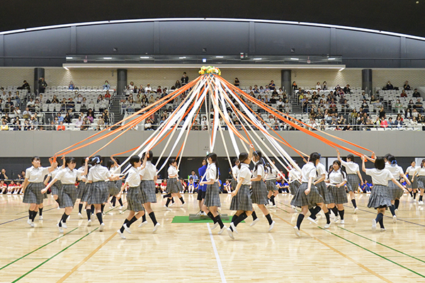 高校3年生による「メイポールダンス」の様子。色とりどりのリボンが丁寧に編み込まれ、後輩や教員、保護者を魅了した