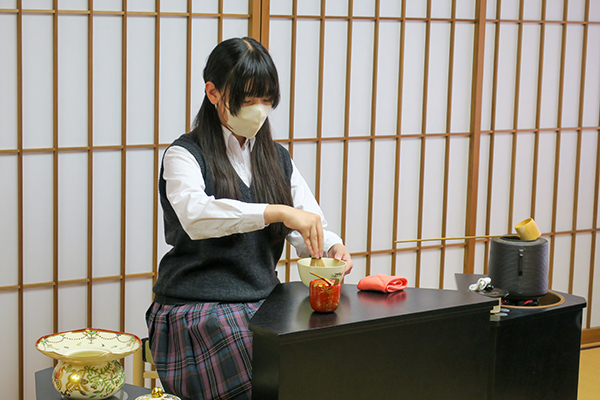 和躾部(茶道)の体験企画で丁寧にお茶を点てる生徒の様子
