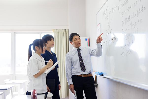先生と生徒2名。ホワイトボード前で学びを深めている様子