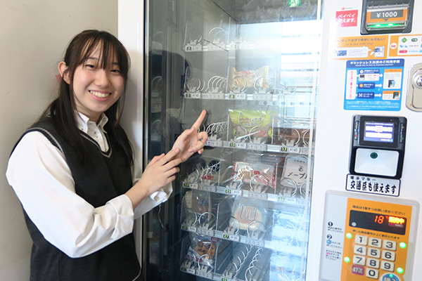 バラエティ豊かなパンが並ぶパンの自販機を紹介する西脇さん
