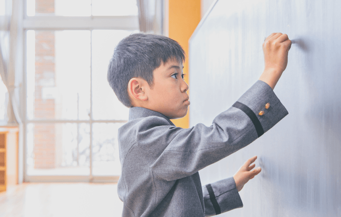 黒板に板書している男子児童