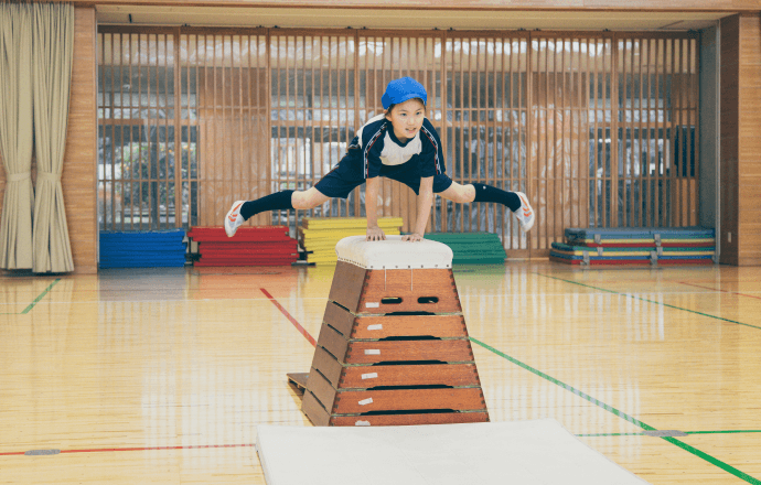 跳び箱を飛んでいる女子児童