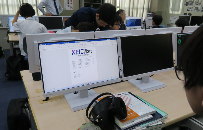 インターネットで鉄道会社を調べている高輪中学高等学校旅行・鉄道研究部部員の写真