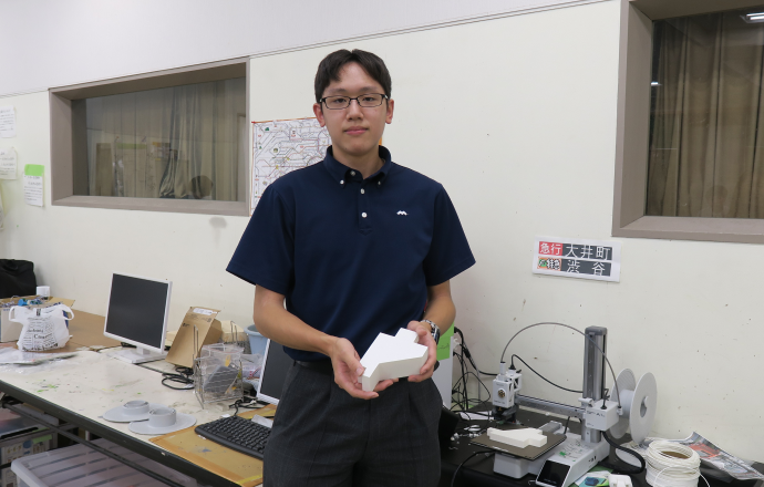 「模型を手にするH.M.さんの写真