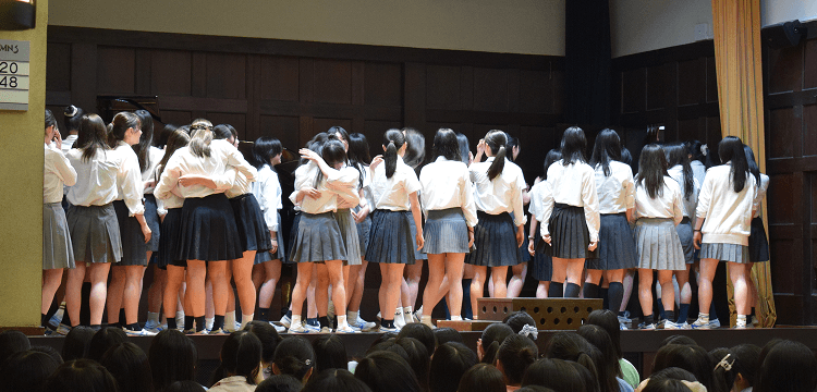 壇上で抱き合う生徒の写真