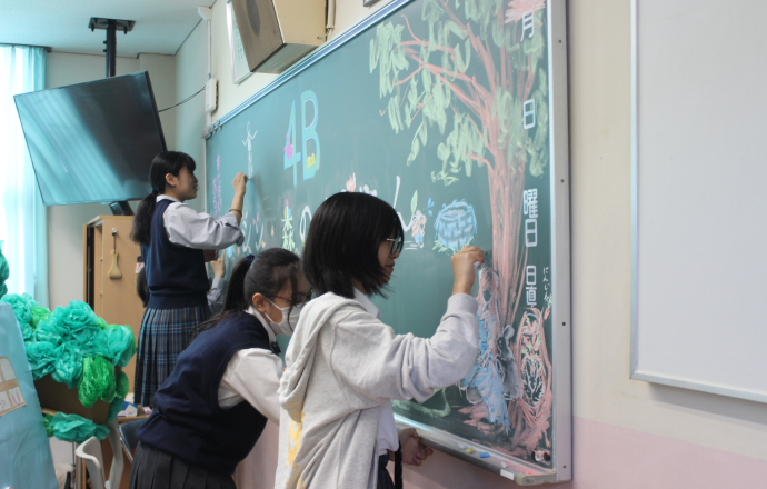 女子生徒数名が黒板アートをしている様子