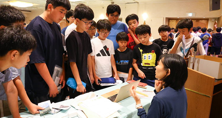 学習会の夜、約15人の生徒が先生の前で説明を受けています